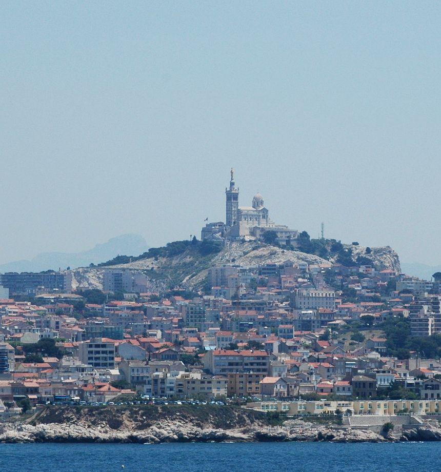 Notre-Dame de la Garde sur sa colline, au-dessus des toits de Marseille, vue depuis la mer
