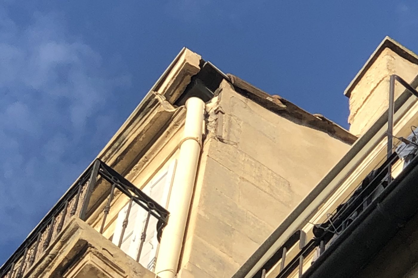 Façade d'un immeuble ancien de Marseille, corniche abîmée sous la toiture