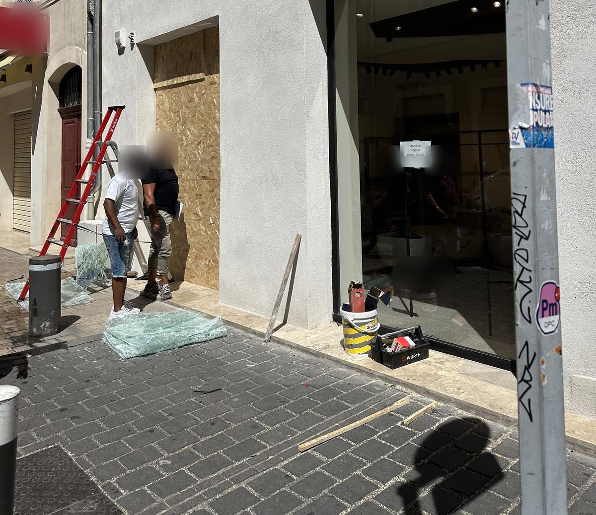 Vitrine condamnée par des panneaux de bois après le pillage d'un commerce à Marseille