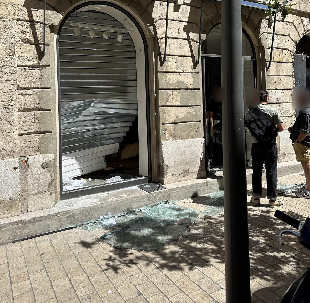 Rideau métallique forcé et vitrine brisée d'un commerce pillé à Marseille